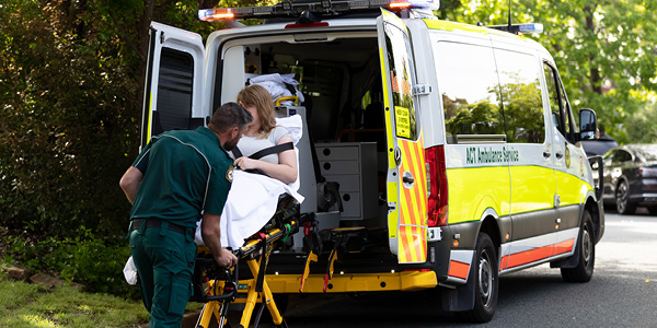 A paramedic loading a patient into an ambulance