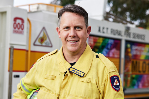 Photo of a rural firefighter in from of a fire truck