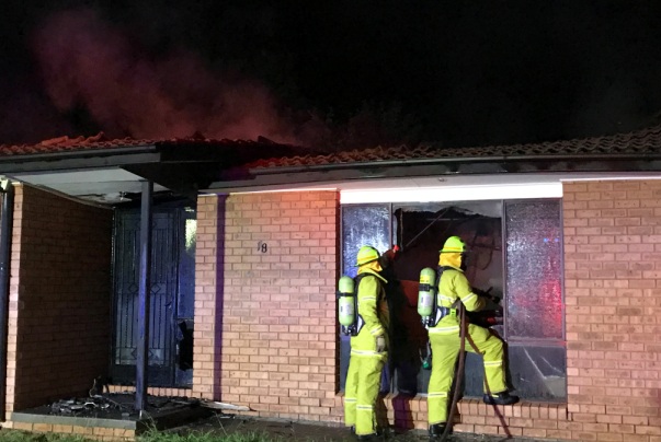 Firefighters wet down inside the home destroyed by fire at Isabella Plains. Photo by Darren Cutrupi.